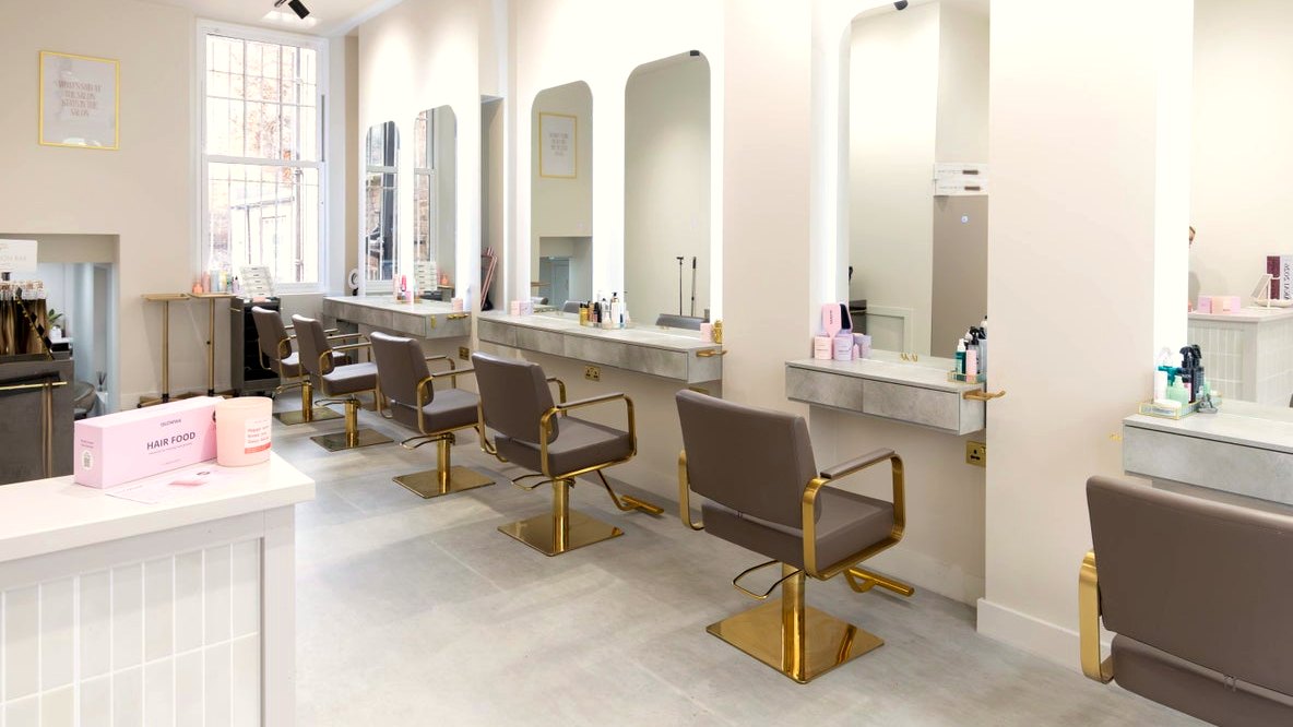 The AKAI salon floor with gold chairs and arched mirrors